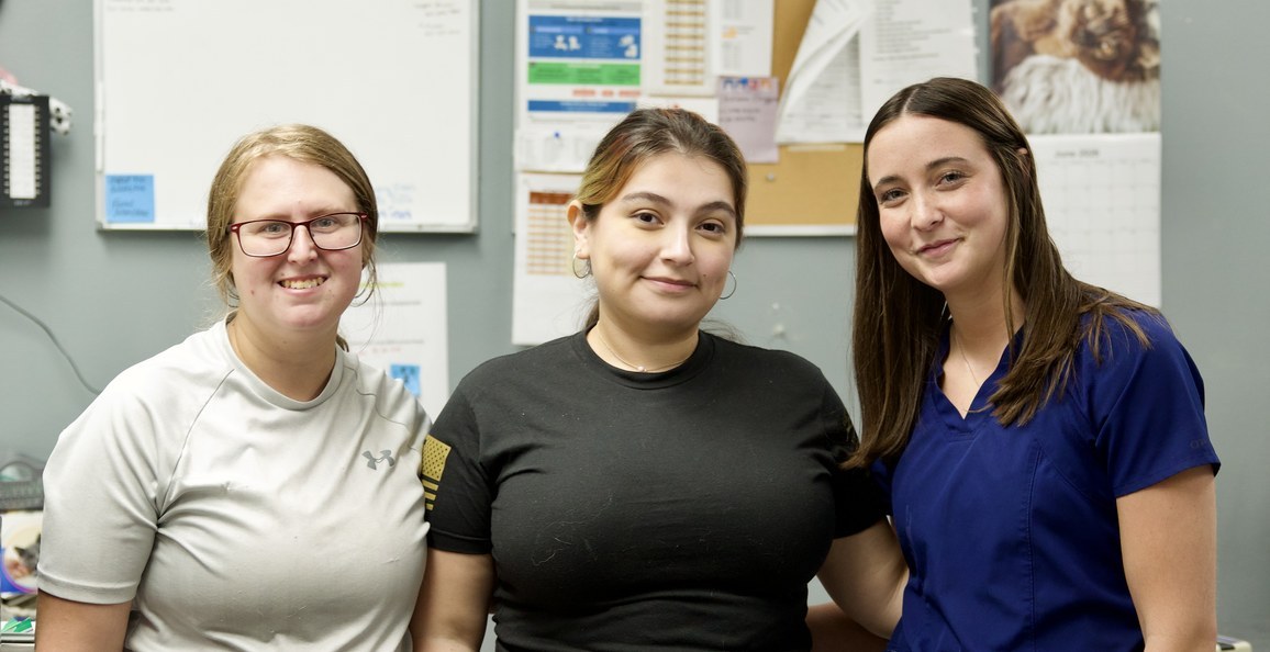 Three smiling members of the Pets Alive clinic team in the treatment area